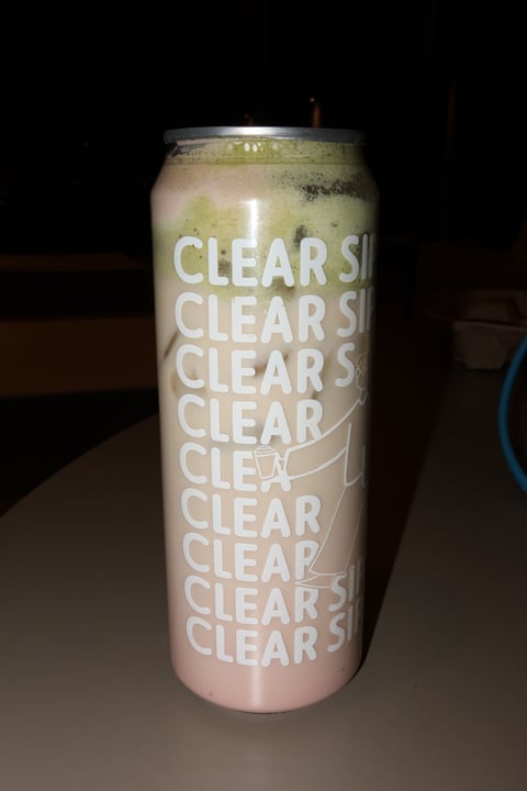Tall pink can with CLEARS text repeated on the label, filled with a light green carbonated beverage
